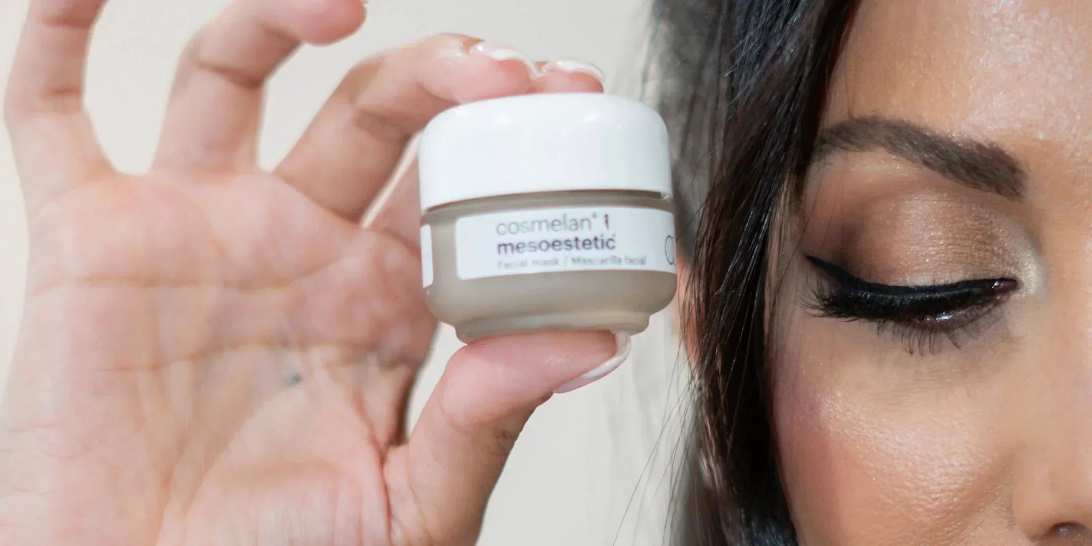 Woman holding Cosmelan 1 Mesoestetic facial cream jar near face, pigmentation treatment