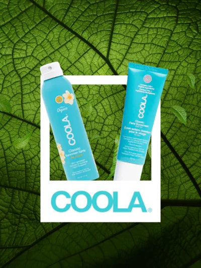 Coola sunscreen spray and face lotion on green leaf background, skincare products