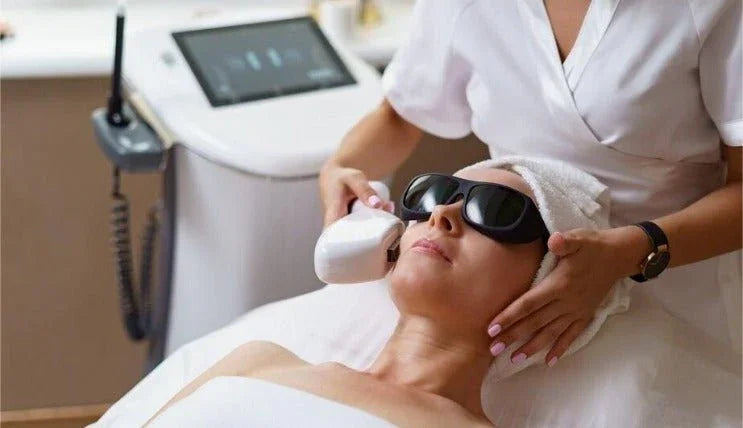 Woman receiving laser hair removal facial treatment at a clinic, wearing protective goggles