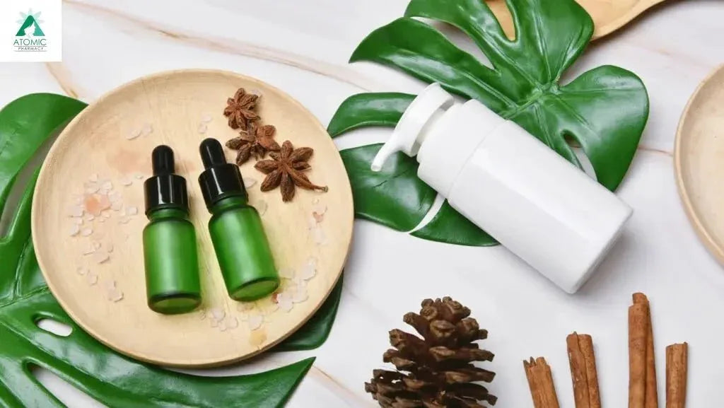 Natural skincare bottles, green leaves, star anise, cinnamon, and pinecone on marble background